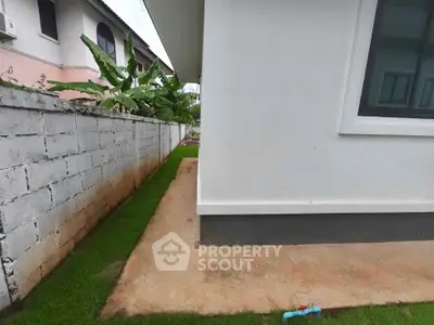 Side view of modern house exterior with garden and concrete path