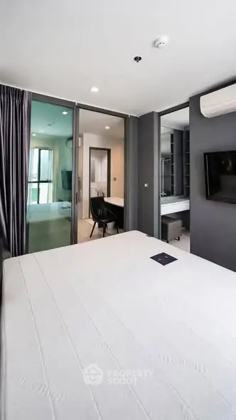 Modern bedroom with sleek design and ensuite bathroom in a contemporary apartment.