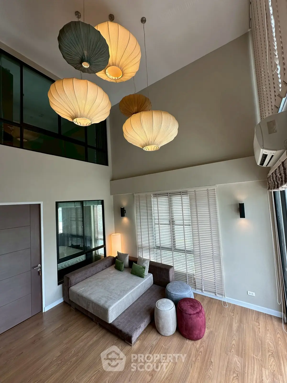 Spacious modern living room with high ceiling and stylish pendant lights