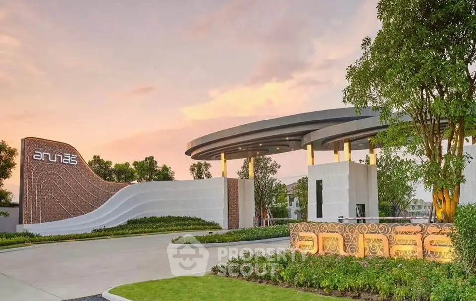 Stunning modern entrance of a luxury residential complex at sunset, showcasing elegant architectural design.