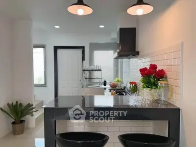 Modern kitchen with sleek black countertops and stylish lighting
