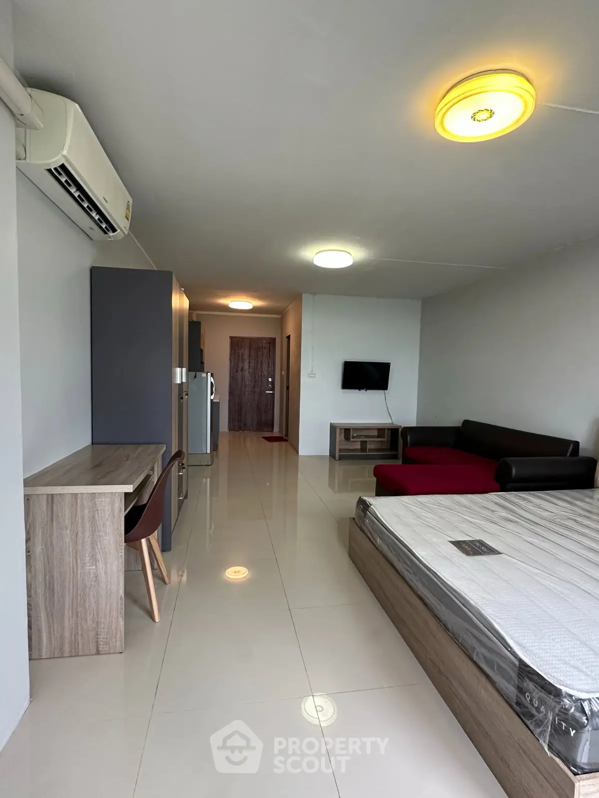 Modern studio apartment with sleek furnishings and ample natural light, featuring a cozy living area and stylish decor.