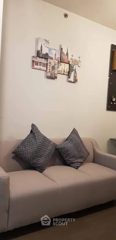 Cozy living room with stylish sofa and decorative wall art, perfect for relaxation.