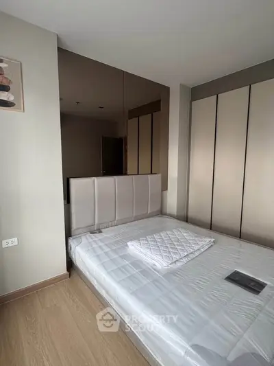 Modern bedroom with sleek design and ample storage in a stylish apartment.