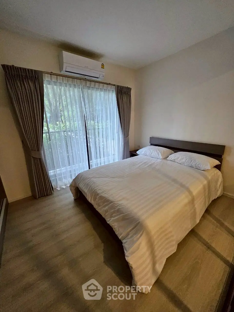 Cozy bedroom with large window and modern decor, perfect for relaxation and comfort.