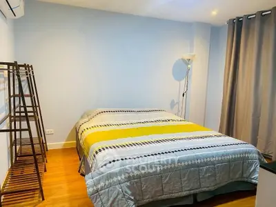 Cozy bedroom with modern decor and stylish lighting, perfect for relaxation.