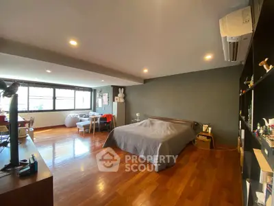 Spacious bedroom with wooden flooring and modern decor