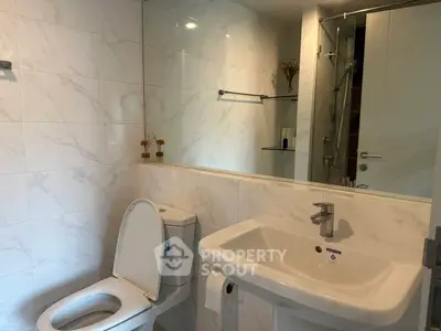 Modern bathroom with sleek white fixtures and elegant marble tiles