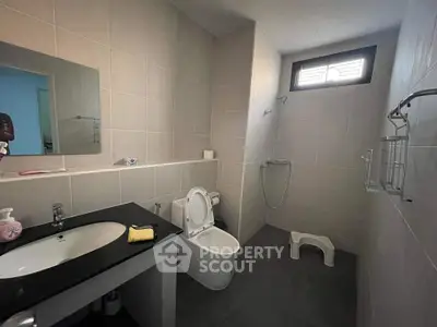Modern bathroom with sleek fixtures and natural light, featuring a shower and elegant vanity.