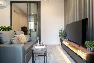 Modern living room with sleek furniture and large TV, perfect for relaxation and entertainment.