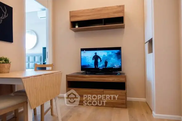 Cozy living room with modern wooden furniture and TV setup, perfect for relaxation.