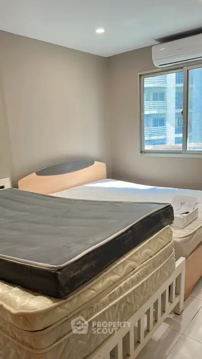 Cozy bedroom with air conditioning and natural light, featuring a double bed and modern decor.