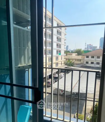 City view from a balcony with modern railing and nearby buildings