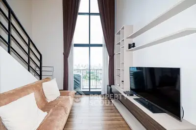 Modern living room with high ceiling and large window offering city view.