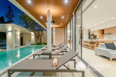 Luxurious modern villa with poolside lounge chairs and open living space