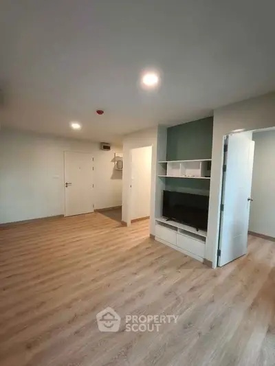 Spacious modern living room with wooden flooring and built-in TV unit
