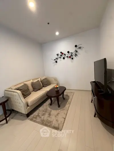 Cozy living room with elegant sofa and wall decor, perfect for relaxation.