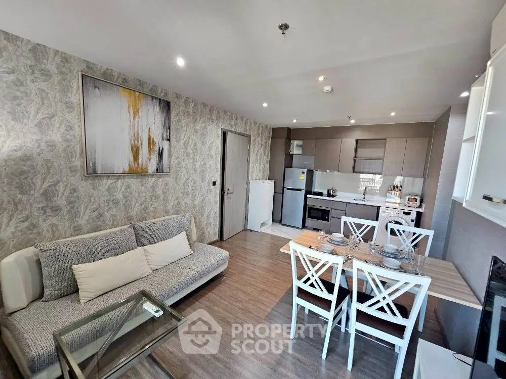Modern open-layout kitchen and living room with stylish decor and dining area.