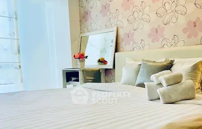 Charming bedroom with floral wallpaper and cozy bedding, perfect for relaxation.