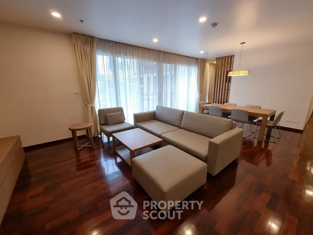 Spacious living room with modern furniture and large windows in a stylish apartment.