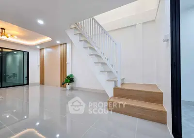 Modern interior with sleek staircase and glossy tiled flooring, perfect for contemporary living.