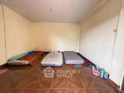 Spacious room with tiled flooring and air mattresses, ideal for temporary accommodation.