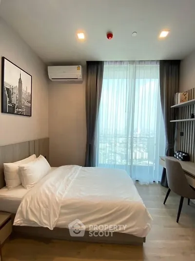 Modern bedroom with city view, featuring a cozy bed and stylish decor.