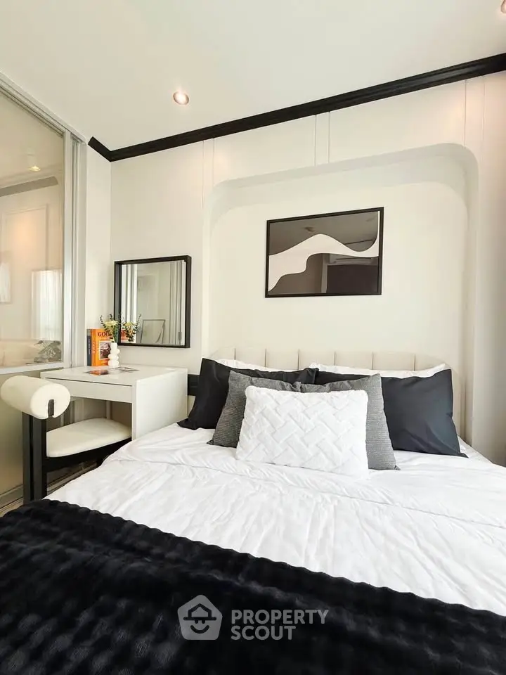 Modern bedroom with stylish decor and cozy bedding in a contemporary apartment.