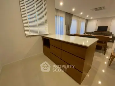 Spacious modern living room with sleek furniture and ambient lighting.