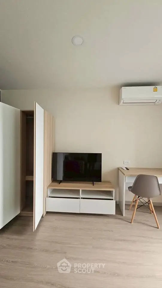 Modern minimalist living room with TV, desk, and air conditioning
