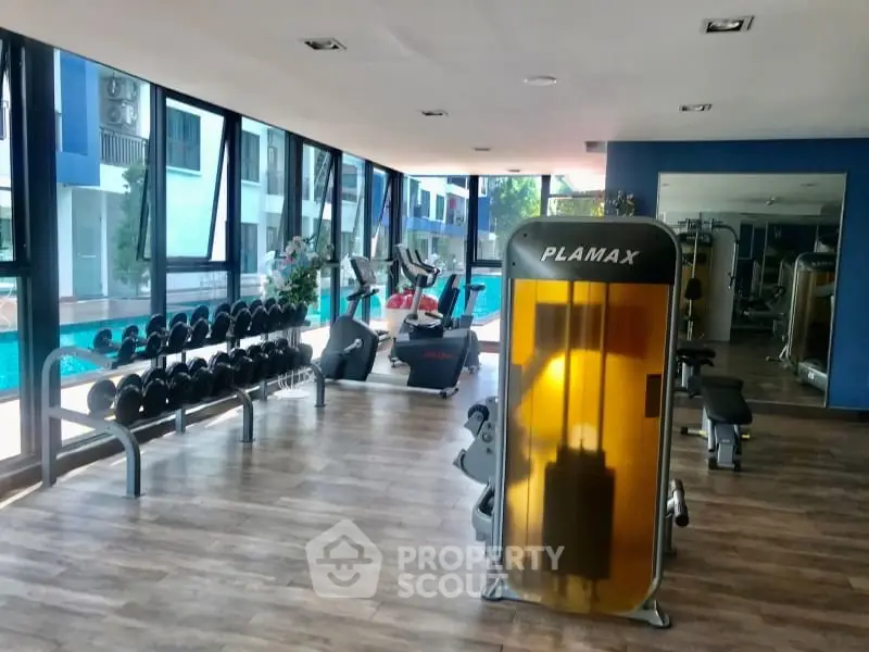 Modern gym with pool view in luxury apartment complex