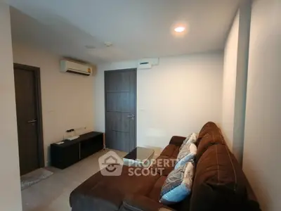 Cozy living room with modern brown sofa and air conditioning in a stylish apartment.