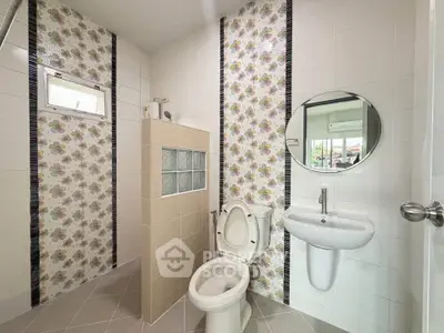 Modern bathroom with floral tile accents and round mirror