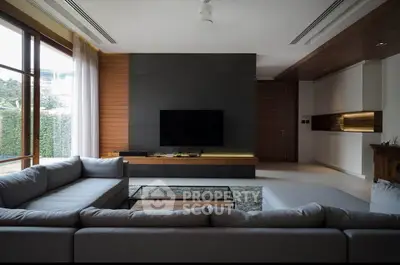Spacious modern living room with large sectional sofa and sleek entertainment center.