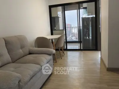 Modern living room with cozy sofa and dining area, featuring a balcony view.