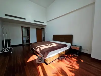 Spacious bedroom with wooden flooring and modern decor