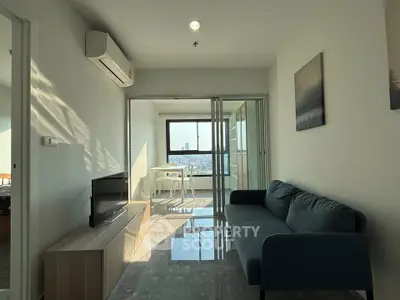 Modern living room with sleek furniture and city view, featuring a cozy sofa and natural light.