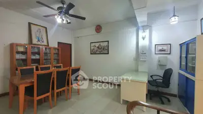 Spacious study room with elegant wooden furniture and ample lighting, perfect for work or study.