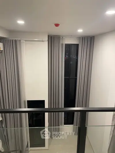 Modern high-ceiling interior with tall windows and elegant curtains