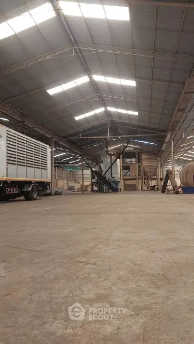 Spacious industrial warehouse with high ceilings and ample natural light, ideal for storage or manufacturing.