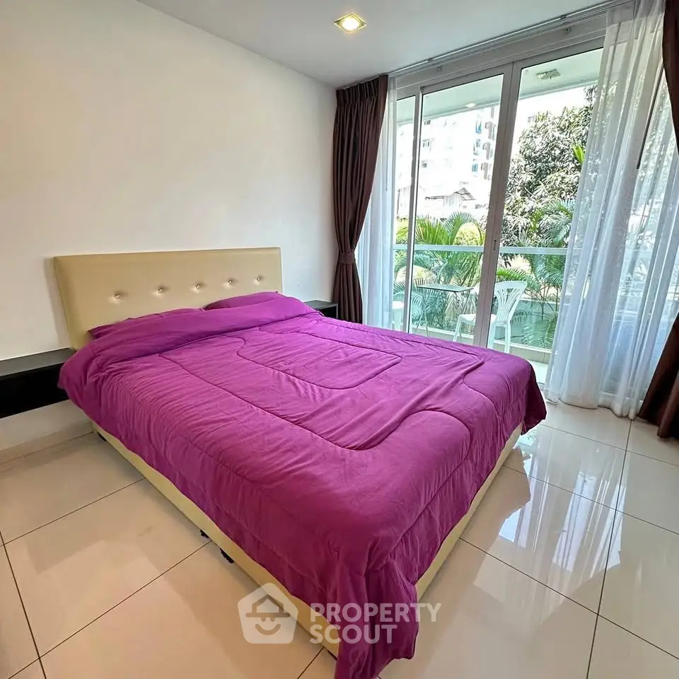 Spacious bedroom with modern decor and balcony view in a luxury apartment.