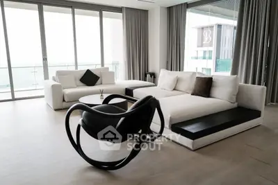 Luxurious modern living room with sleek furniture and floor-to-ceiling windows offering stunning views.
