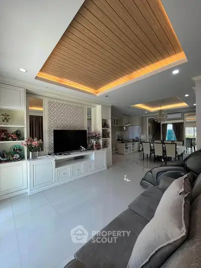 Luxurious living room with modern decor and open layout, featuring elegant ceiling design and spacious seating area.