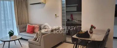 Modern living room with open kitchen, stylish furniture, and natural light in a contemporary apartment.