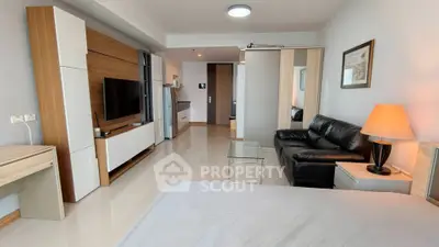 Modern studio apartment with sleek furnishings and open layout, featuring a cozy living area and stylish decor.