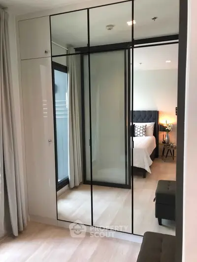 Modern bedroom with glass wardrobe and elegant decor in a stylish apartment.