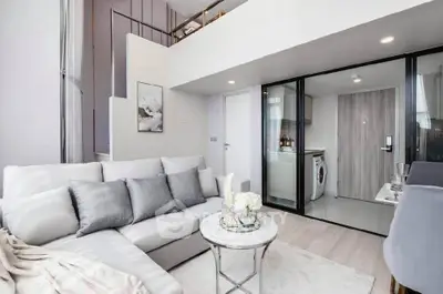 Modern duplex living room with stylish decor and open kitchen layout.
