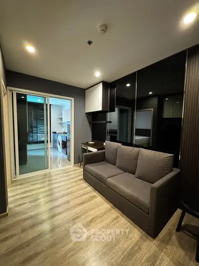 Modern living room with sleek design and view into kitchen with washing machine