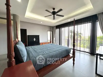 Luxurious bedroom with elegant four-poster bed and large windows offering scenic views.