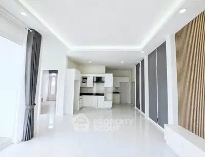 Spacious modern living room with open kitchen layout and elegant ceiling design